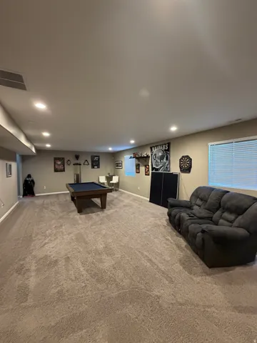 Spacious room with recessed lighting and neutral-toned walls