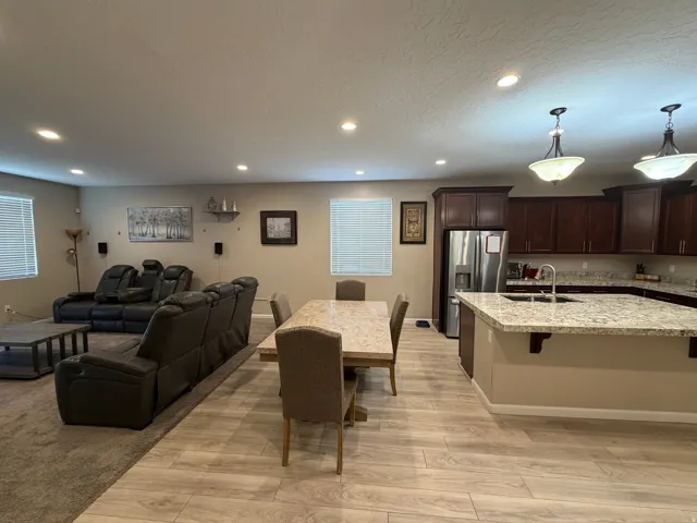Open-concept living area featuring wood-finish flooring, recessed lighting, and ample natural light from multiple windows