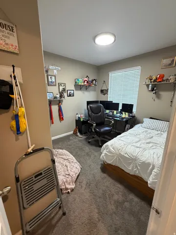 Room featuring wall-to-wall carpeting, neutral wall paint, and a window with blinds