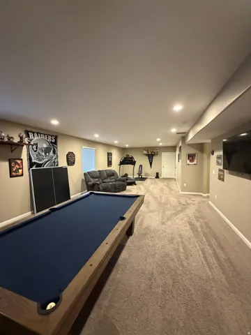 Spacious finished lower level featuring recessed lighting, a neutral color palette, and textured carpeting