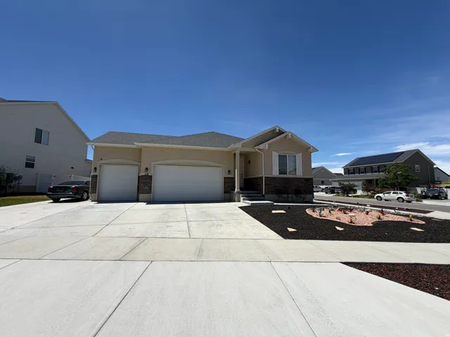 Cream stucco exterior with dark brick veneer accents