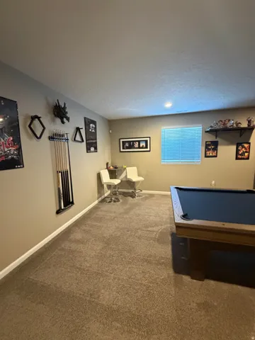 Carpeted room with a recessed light fixture and a window with blinds