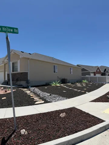 Modern xeriscape landscaping featuring dark lava rock, a stone pathway, and mature agave plants