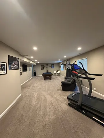 Spacious lower-level room featuring recessed lighting, neutral wall tones, and carpet flooring