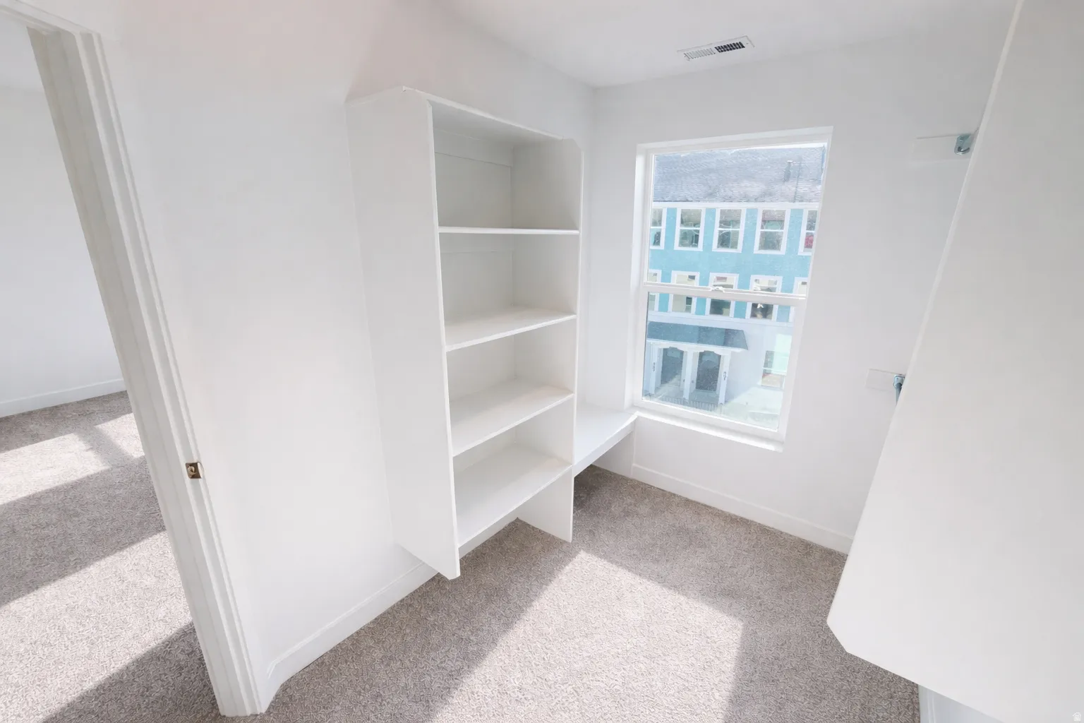 White built-in shelving unit with an integrated desk surface