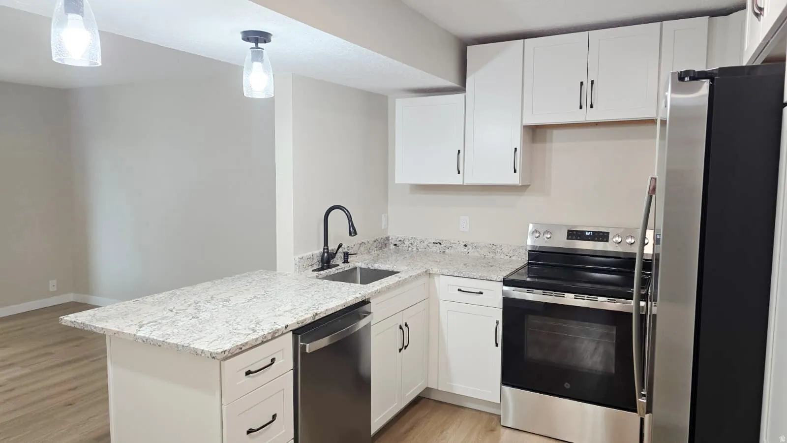 Kitchen featuring white cabinetry, light-toned countertops, a stainless steel dishwasher, a stainless steel range, and a stainless steel refrigerator