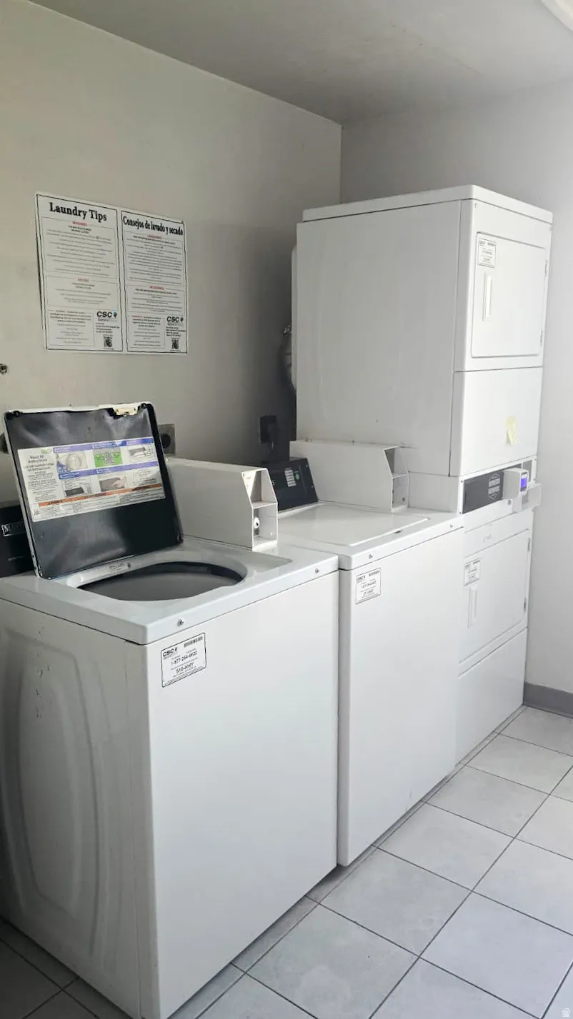 Dedicated laundry area featuring multiple white washers and dryers