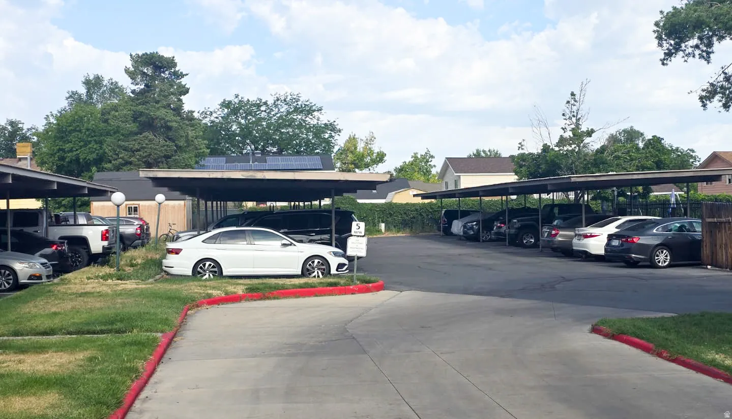Expansive paved parking area featuring multiple covered carports