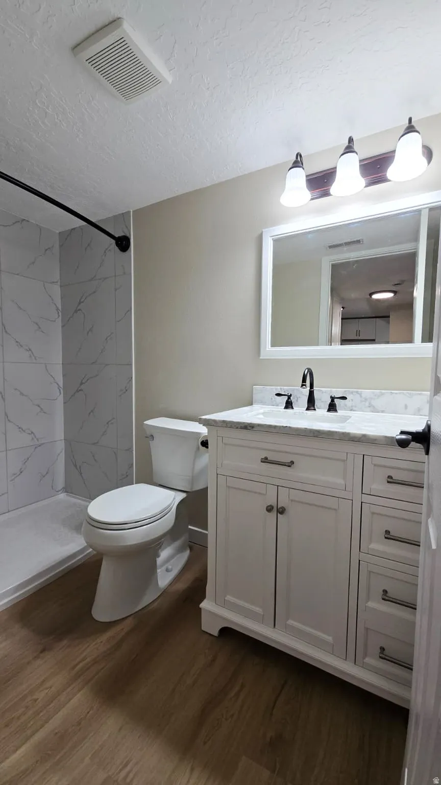 Bathroom featuring a white vanity with a marble-finish countertop, matte black faucet, and rectangular mirror