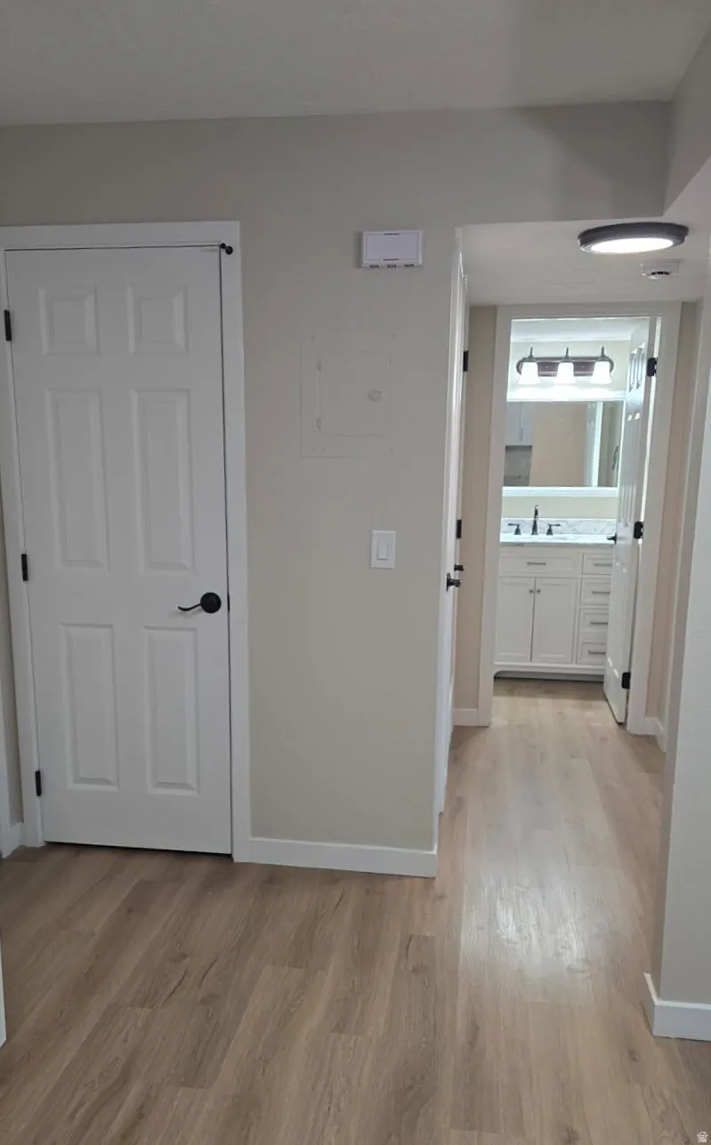 Entryway featuring light wood-finish flooring, white paneled doors, and neutral wall tones