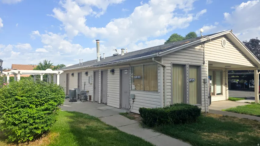 Single-story commercial building featuring light-toned siding and a covered entry