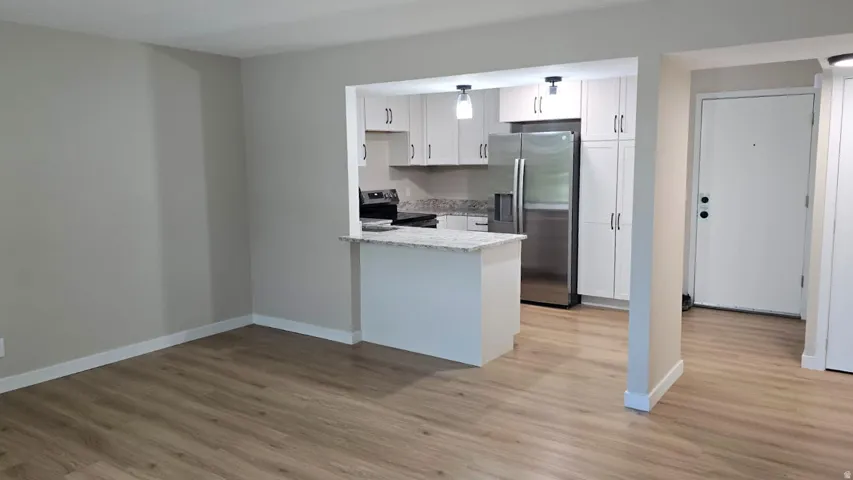 Open-concept living area featuring wood-finish flooring and neutral wall tones