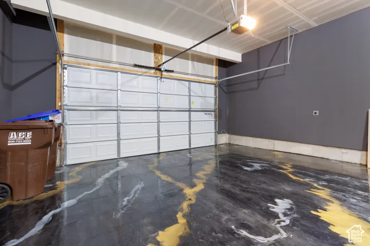 Garage interior featuring a sectional white garage door and an automatic opener