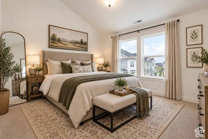 Vaulted ceiling, plush carpet flooring, large windows, and a neutral color palette