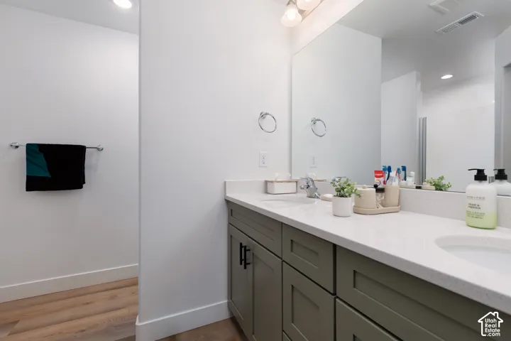 Double vanity with light-colored countertops, dual undermount sinks, and contemporary wall-mounted mirror