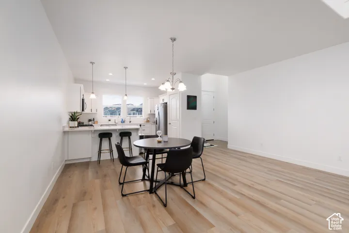 Open-concept living space featuring wood-finish flooring, white walls, and a recessed lighting