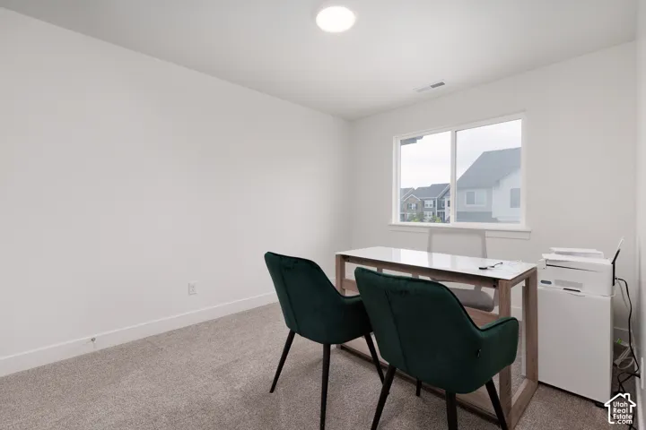 Spacious room featuring neutral carpeting, white walls, and a large window with white trim