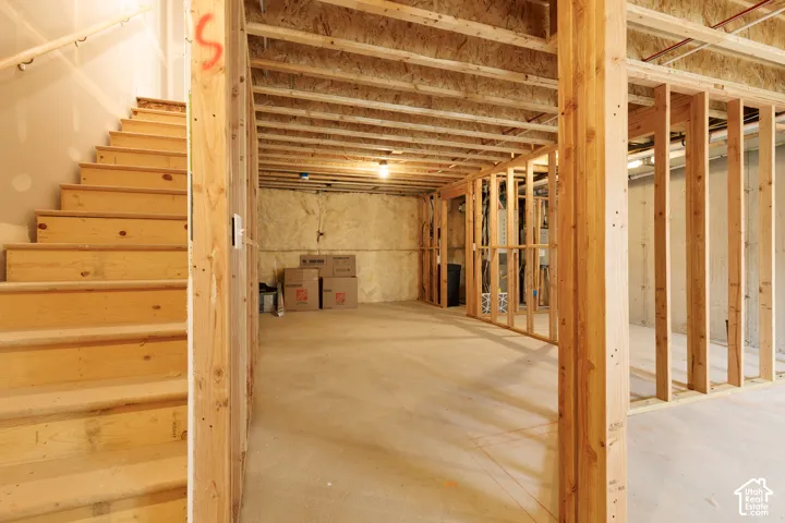 Unfinished lower level featuring wood framing, concrete flooring, and exposed ceiling joists