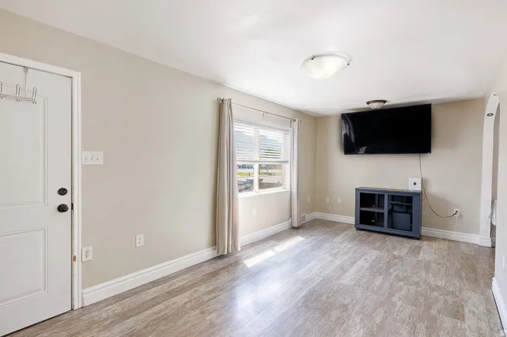Open concept living space featuring light wood-finish flooring, neutral wall tones, and white trim
