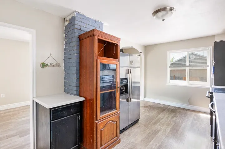 Kitchen featuring wood-finish flooring, light grey painted walls, and a window with horizontal blinds