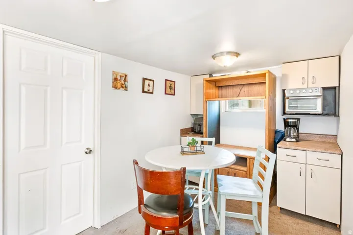 Compact kitchen area featuring light-toned cabinetry and solid surface countertops