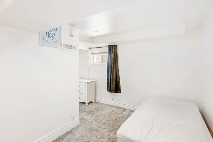 Carpeted room with white walls, a recessed window, and white trim