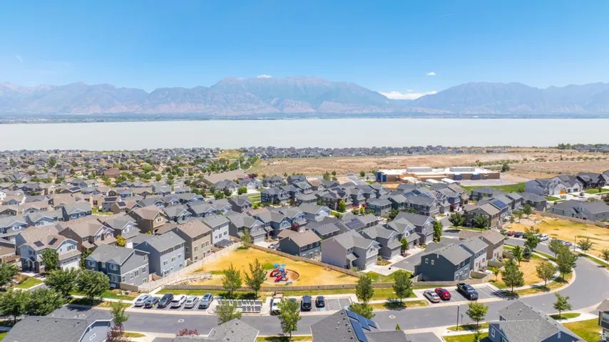 Aerial perspective showcasing a residential community with varied rooflines and a central green space featuring playground equipment