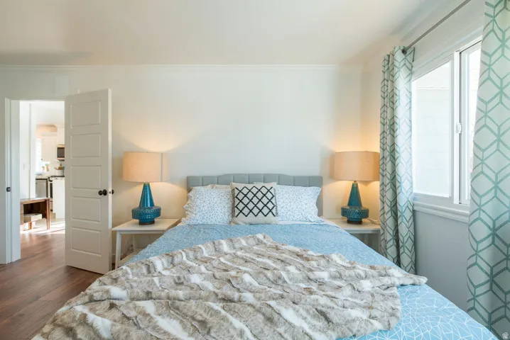 Room featuring wood-finish flooring, a neutral wall color, and white trim