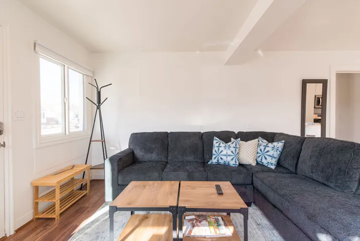 Living area featuring wood-finish flooring, white walls, and a large window