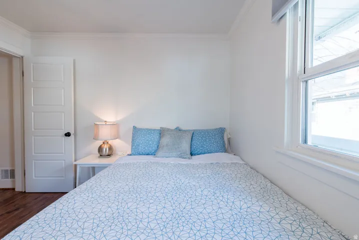 Bright room with wood-finish flooring and a multi-panel interior door