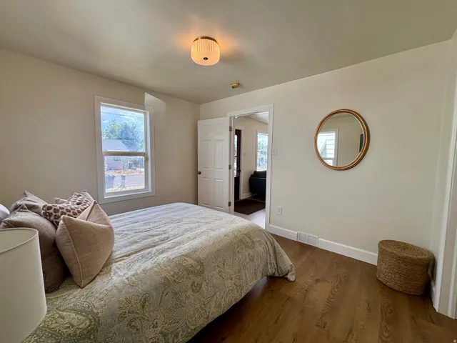 Room featuring wood-finish flooring, neutral wall paint, and white trim
