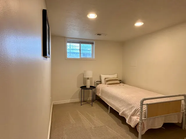 Carpeted room featuring a window with blinds, recessed ceiling lighting, and neutral wall finishes