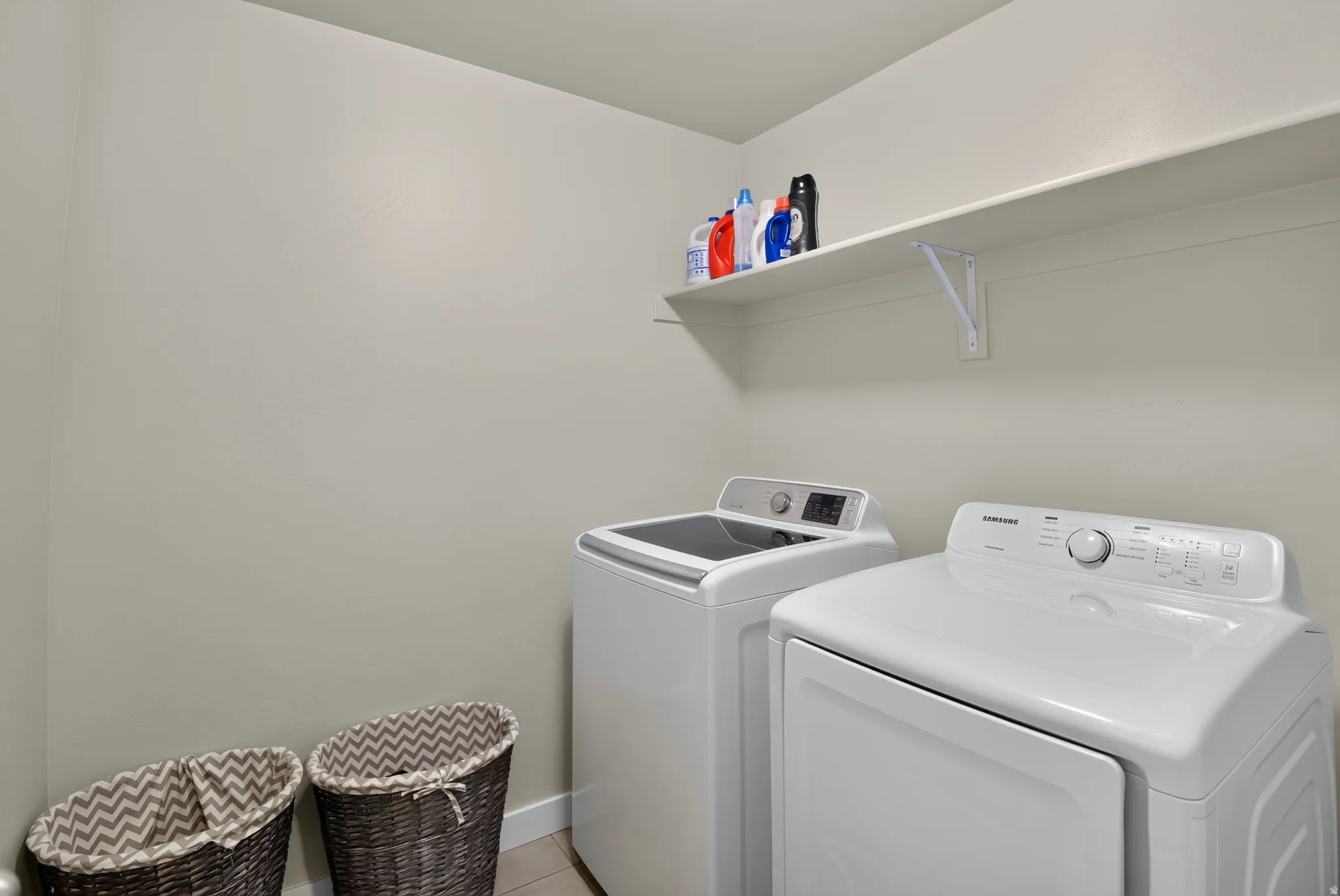Dedicated laundry area featuring a wall-mounted storage shelf