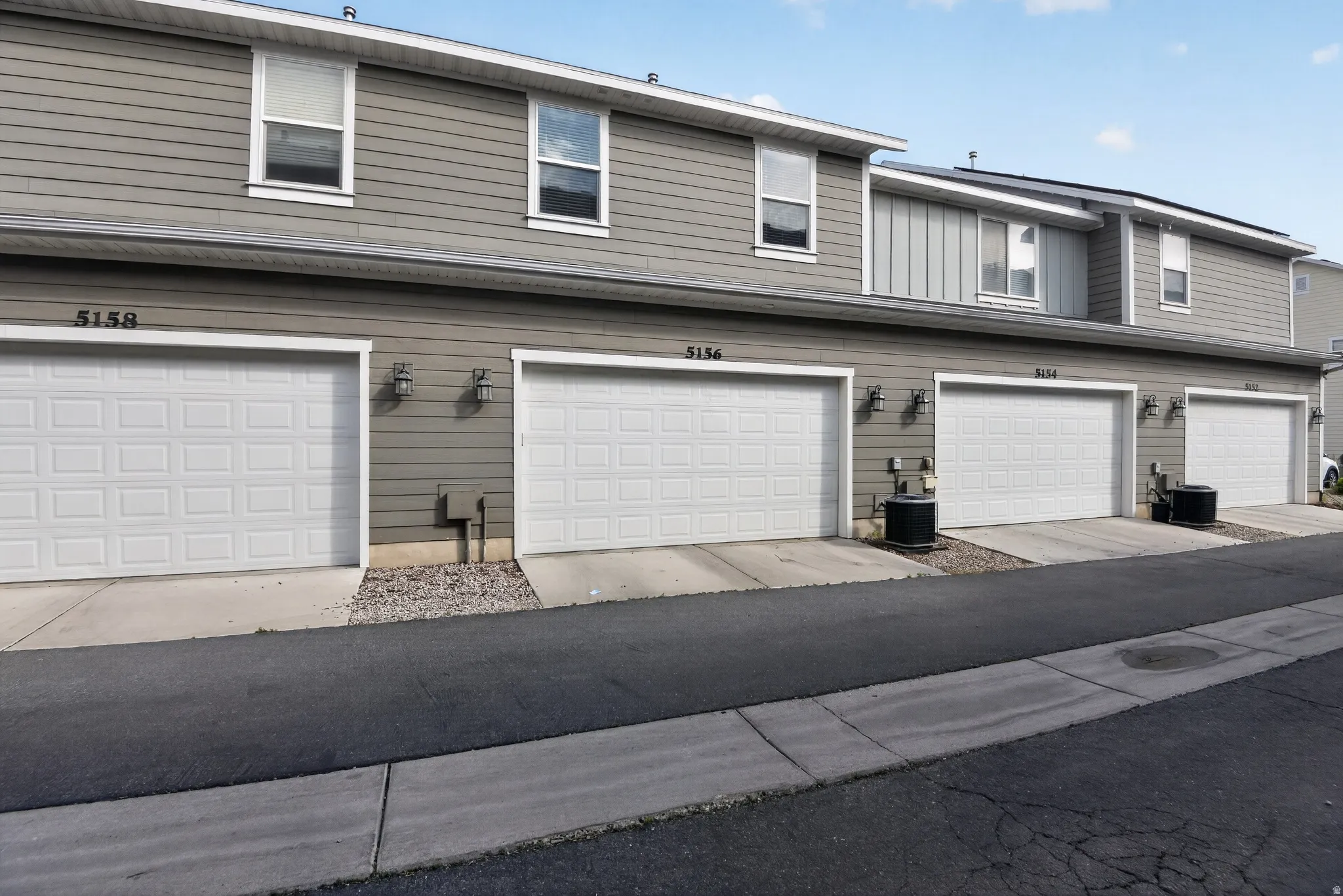 Multi-unit property exterior featuring horizontal siding and individual garage access