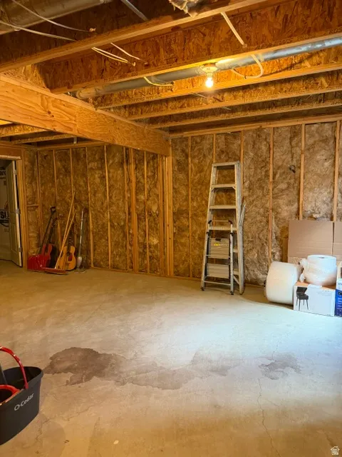 Unfinished basement with exposed wood framing, ceiling joists, and concrete flooring