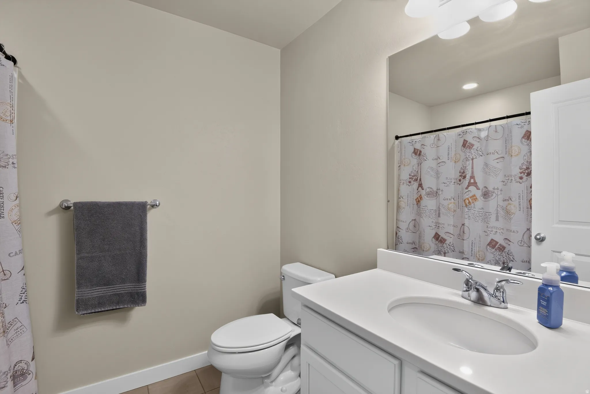 Bathroom featuring a white vanity with an integrated sink, chrome faucet, and a large wall-mounted mirror