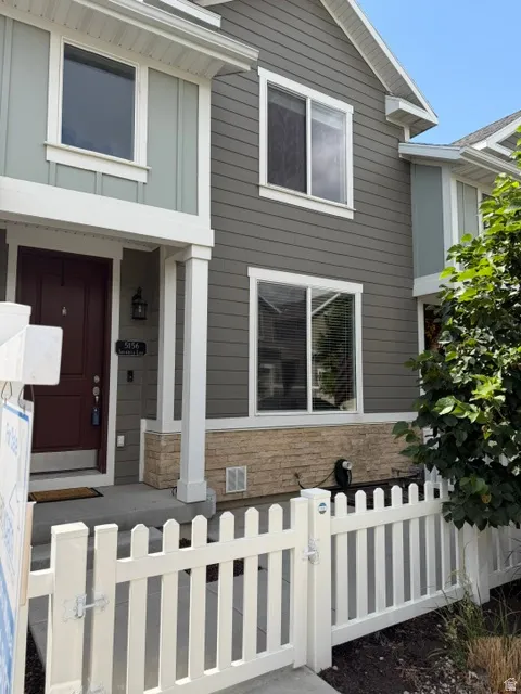 Two-story exterior with multi-toned siding, white trim, and a prominent red entry door