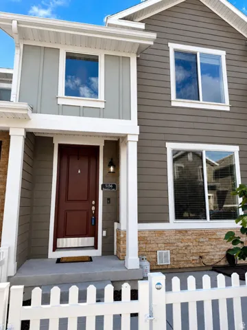 Contemporary exterior featuring a rich brown entry door, white trim accents, and a mixed material facade of siding and stacked stone