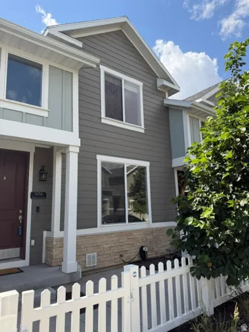 Contemporary exterior featuring horizontal siding in a two-tone gray palette, white trim, and a partial stone facade