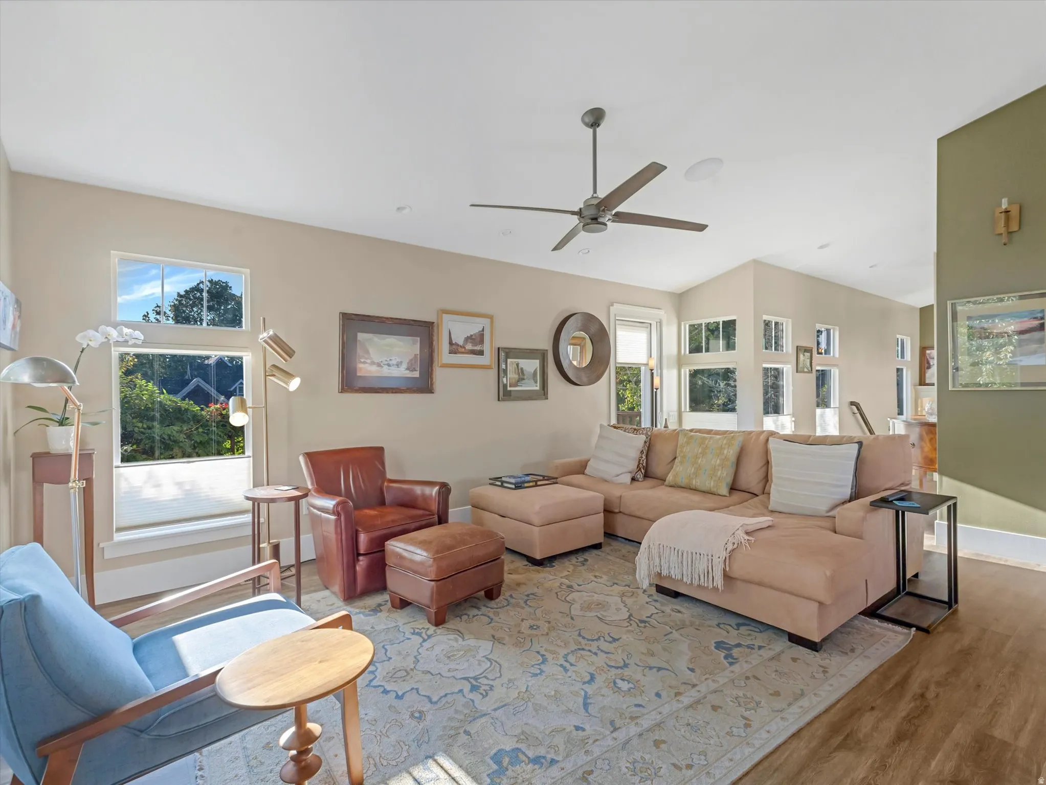 Living room with wood finished floors, plenty of natural light, and ceiling fan