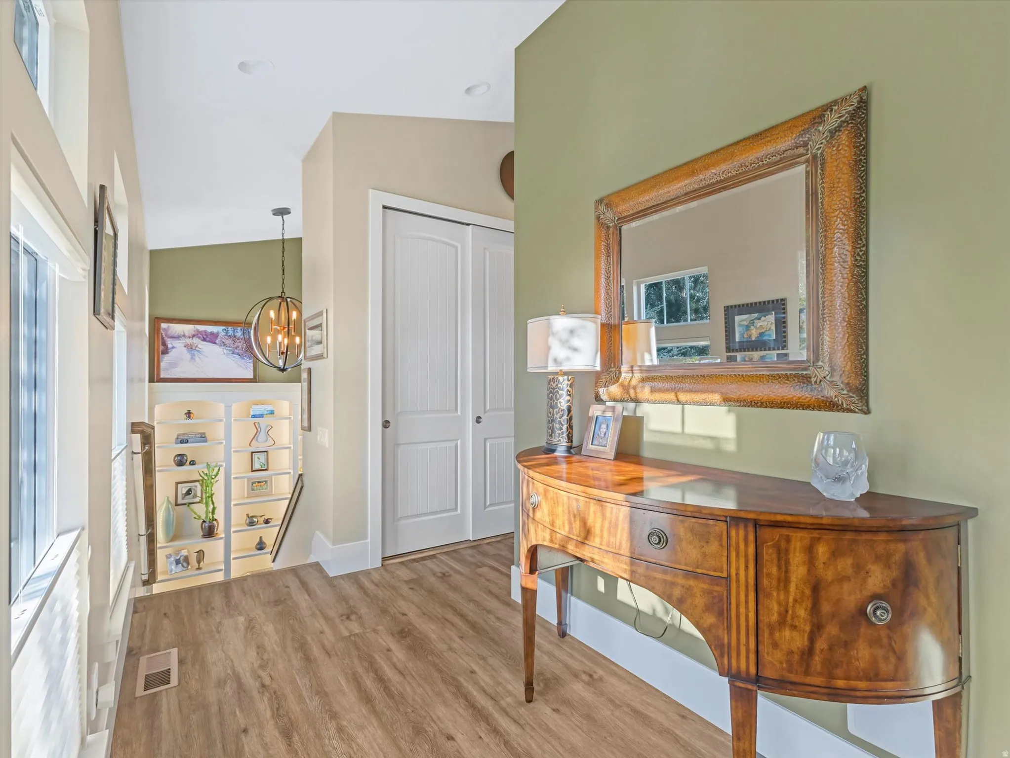 Hallway featuring a chandelier and light wood-style floors