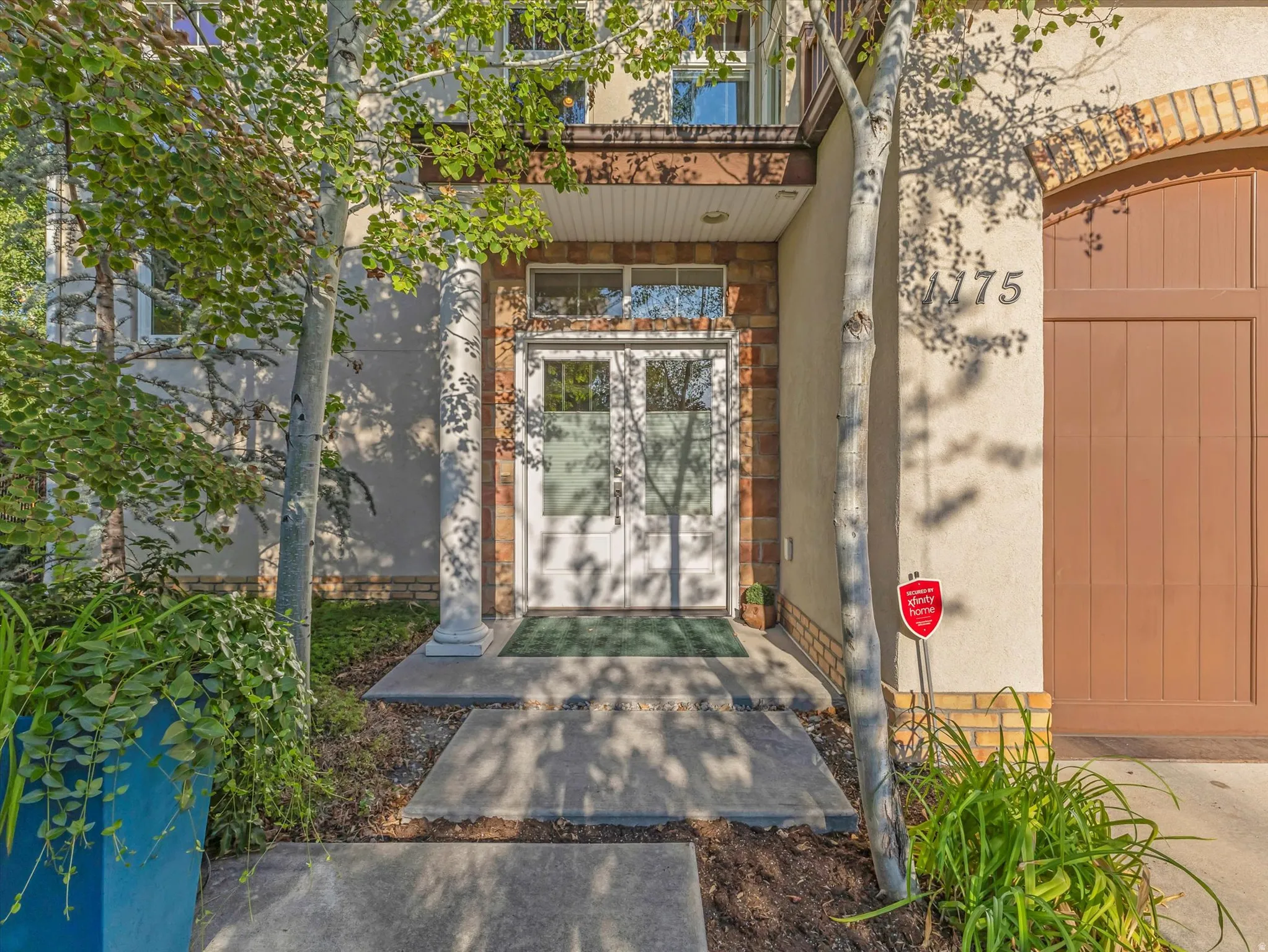 Doorway to property featuring brick siding, stucco siding, and stone siding