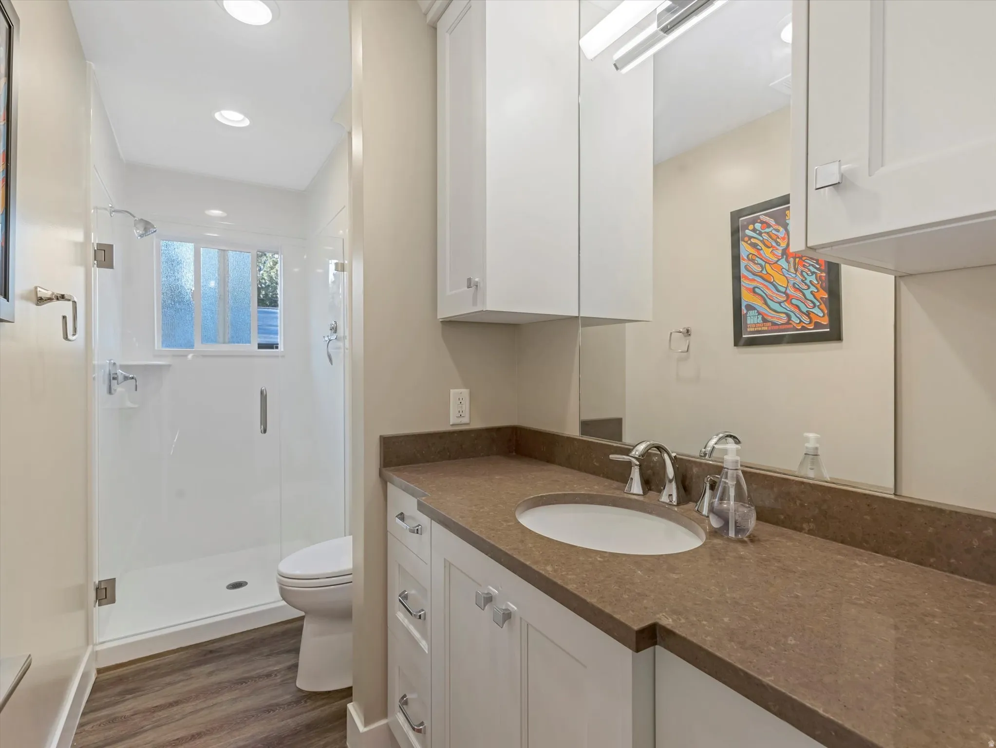 Full bathroom featuring a stall shower, vanity, dark wood-style flooring, and recessed lighting