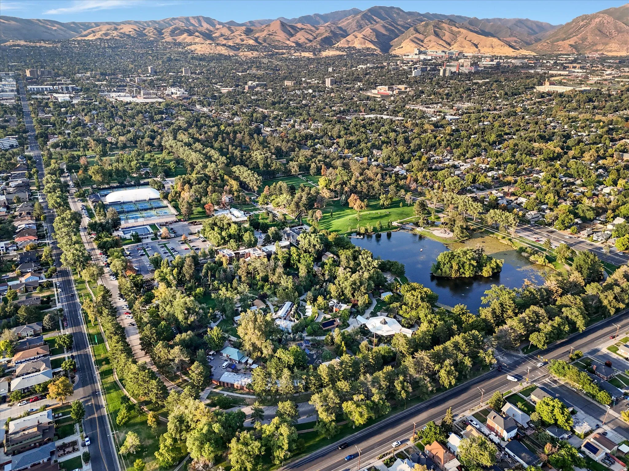 Aerial view of property and surrounding area featuring nearby suburban area and a water and mountain view