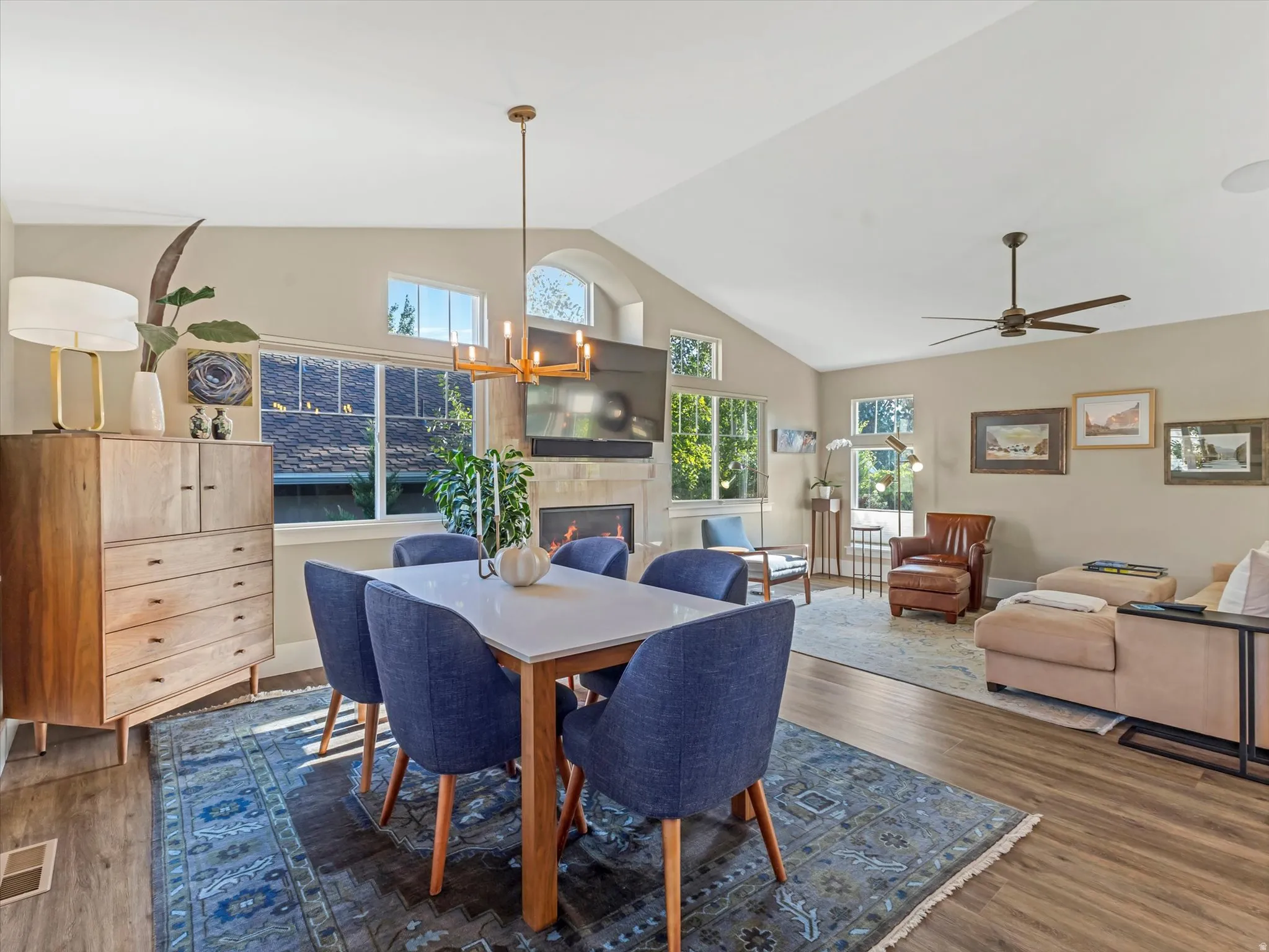 Dining area featuring plenty of natural light, a fireplace, dark wood finished floors, and high vaulted ceiling