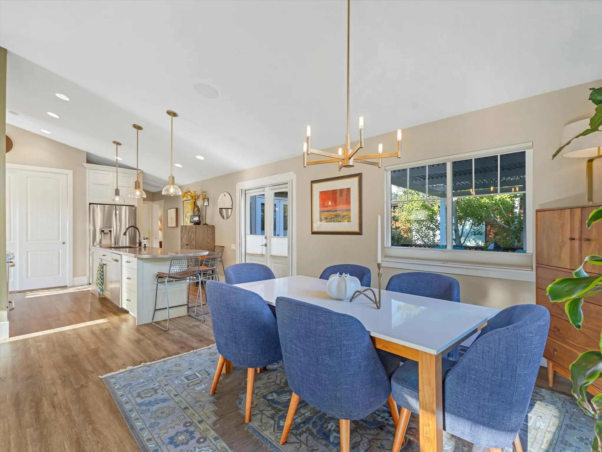 Dining room featuring light wood-style flooring, vaulted ceiling, a chandelier, recessed lighting, and french doors