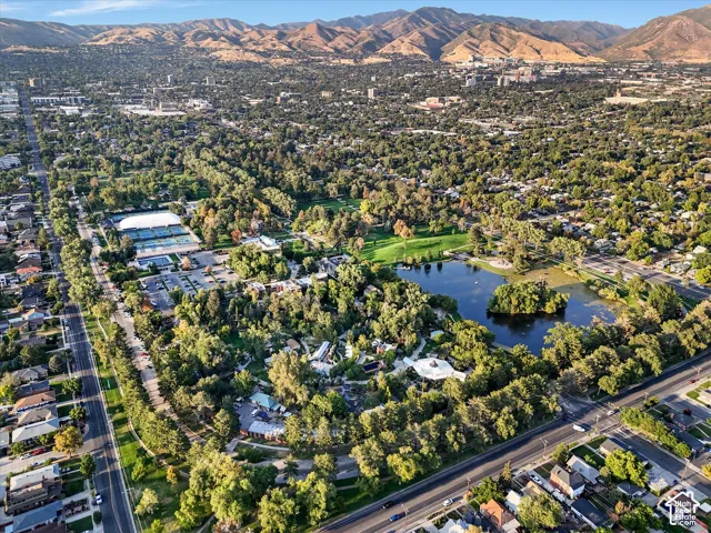 Aerial view of property and surrounding area featuring nearby suburban area and a water and mountain view