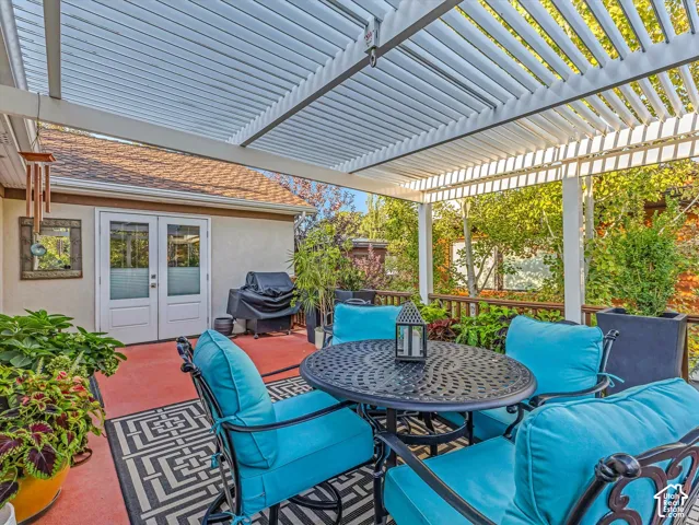 View of deck with french doors, grilling area, and outdoor dining area and a view