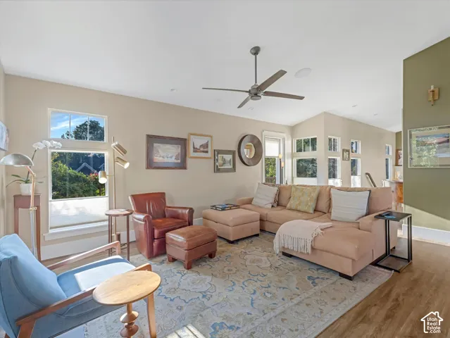 Living room with wood finished floors, plenty of natural light, and ceiling fan