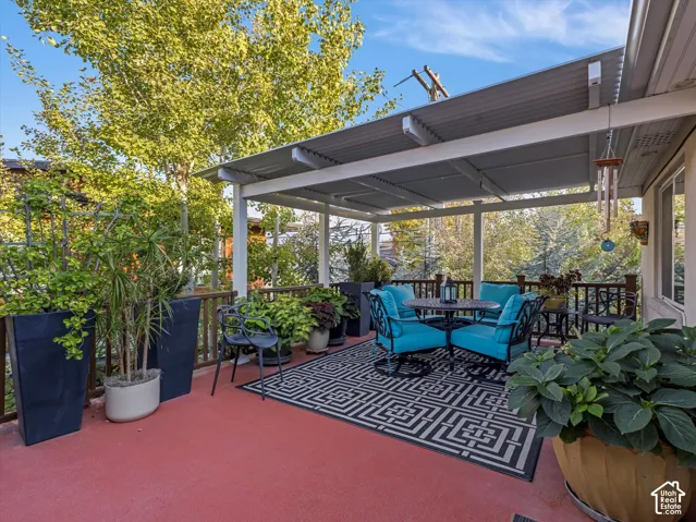 View of deck with outdoor dining space, cover and a view